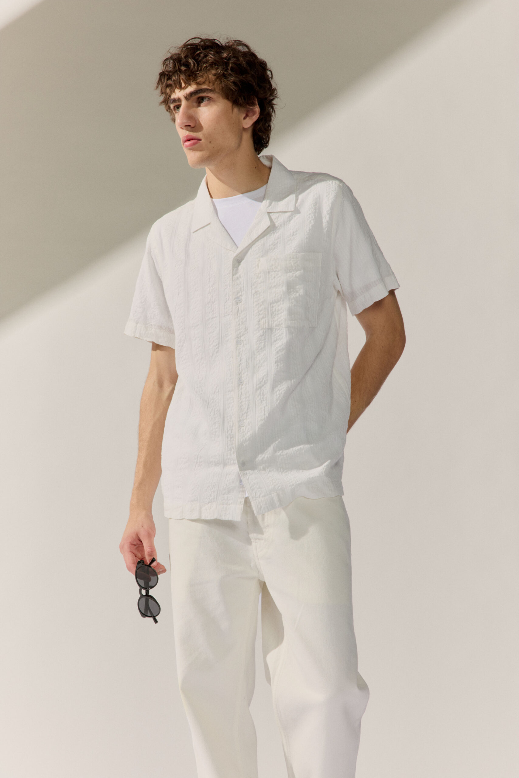 BASEFIELD MEN Model trägt stripe Shirt und eine Sonnenbrille