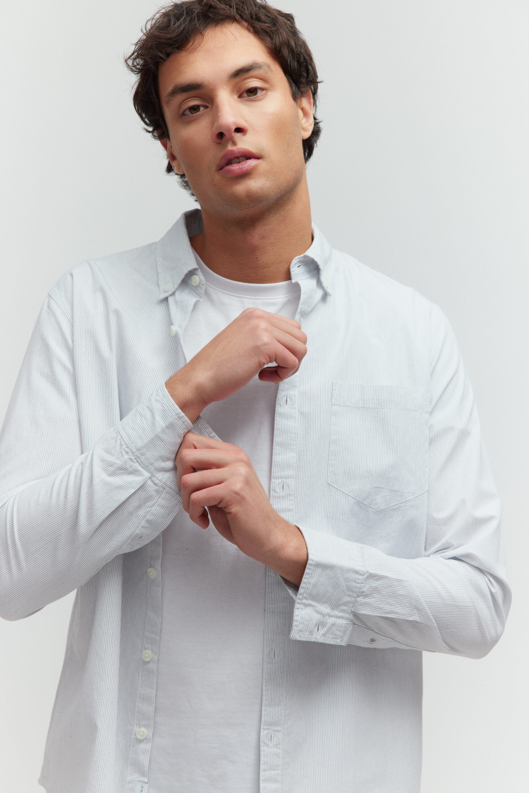 Basefield Men Model trägt mint outift und lehnt sich an einen Stuhl